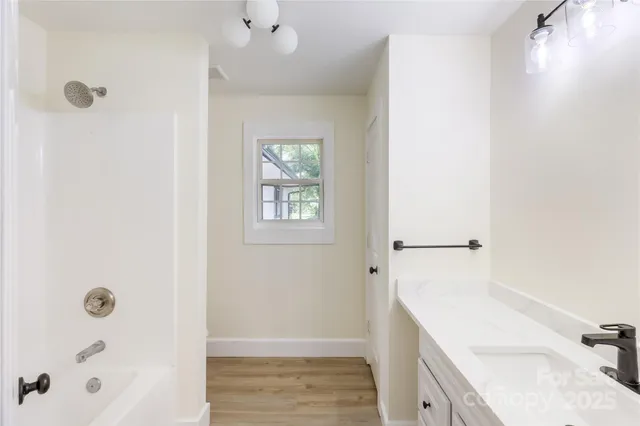 a bathroom with a tub sink and shower