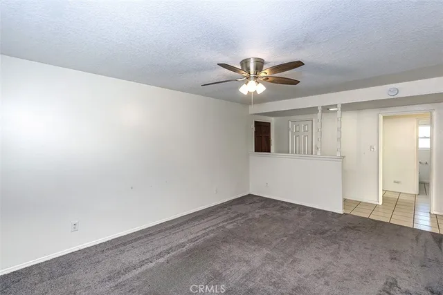an empty room with a ceiling fan and a window