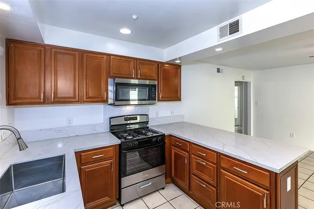 a kitchen with stainless steel appliances granite countertop a sink stove and microwave