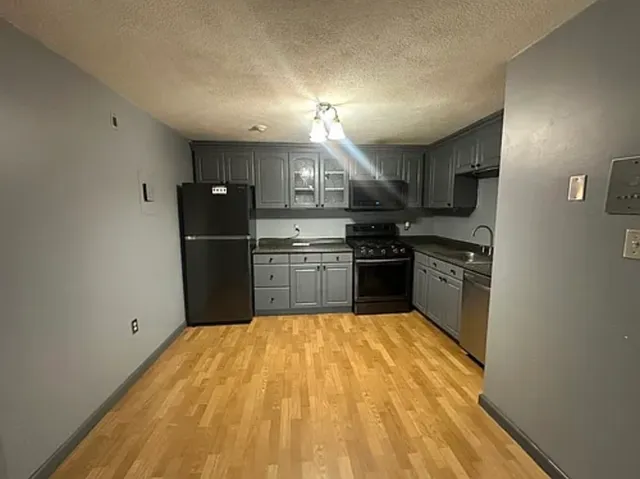 a kitchen with stainless steel appliances granite countertop a refrigerator and a stove