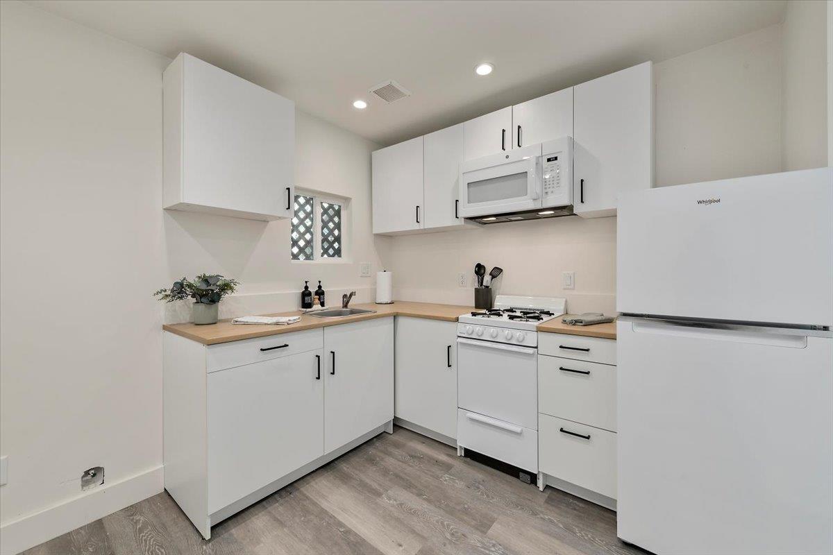 789 Cañada Road Woodside, CA 94062 - Photo 22 of 33 a kitchen with white cabinets sink and white appliances