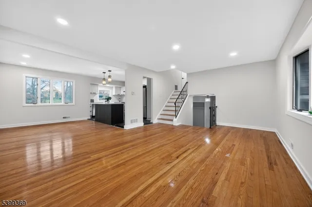 a view of empty room with wooden floor and window