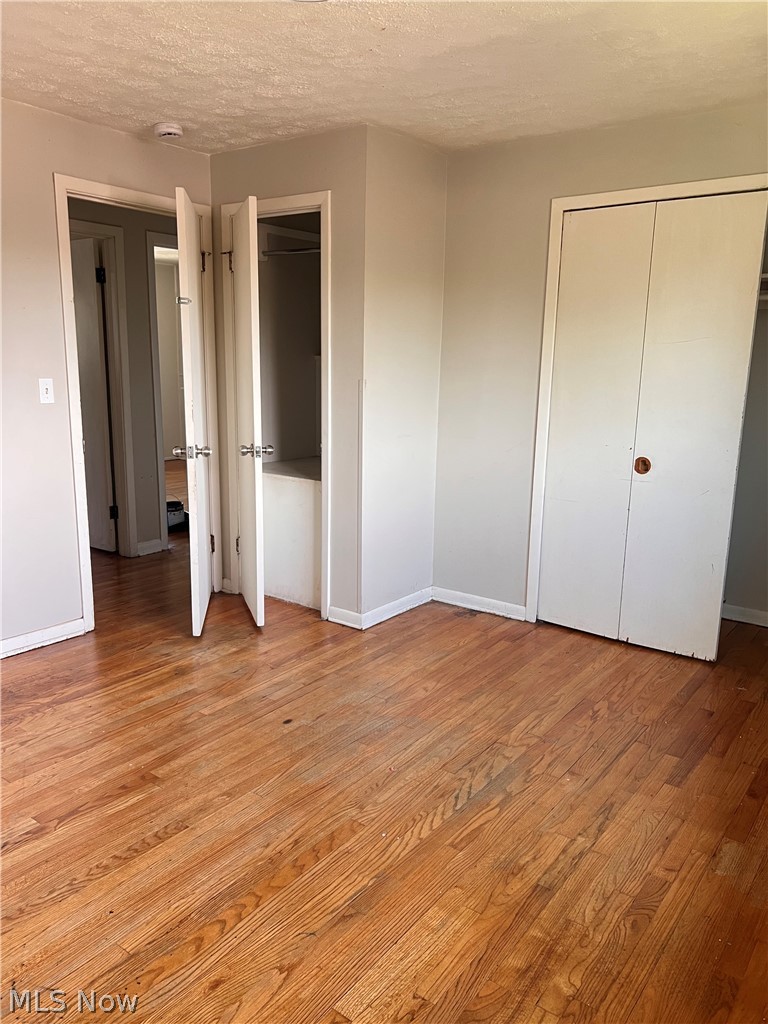 16350 Rockside Road Maple Heights, OH 44137 - Photo 26 of 34 Hardwood flooring throughout featuring light gray walls, white trim, and white bi-fold closet doors
