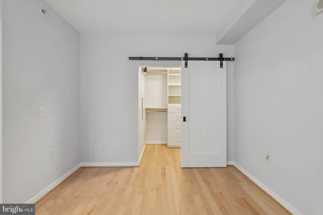 a view of empty room with wooden floor