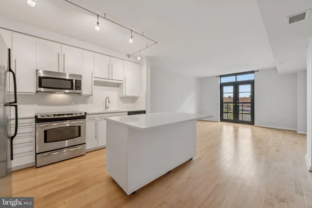 a kitchen with stainless steel appliances a stove top oven and refrigerator