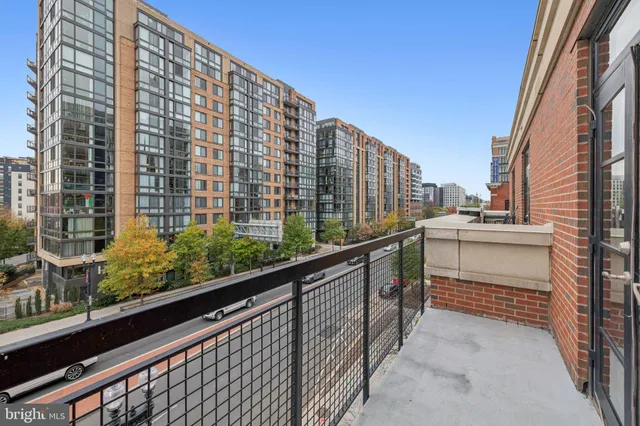 a view of balcony with a couple of cars parked in parking lot