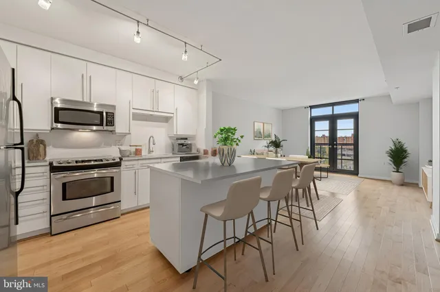 a kitchen with microwave a stove and chairs