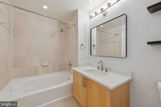 a bathroom with a sink and a mirror with bathtub