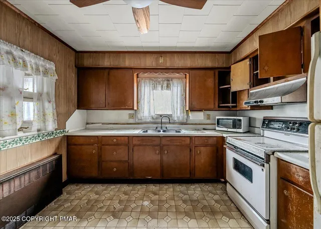 a large kitchen with stainless steel appliances granite countertop a sink and dishwasher a stove with wooden floor
