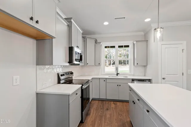 a view of an empty room with wooden floor fireplace and a window