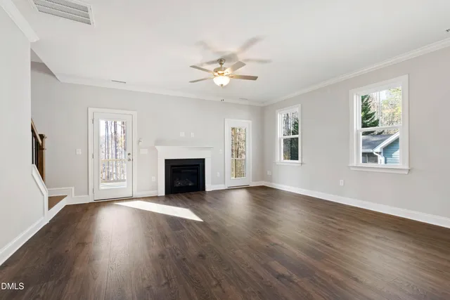 a view of a kitchen with kitchen island a sink wooden floor and a large window