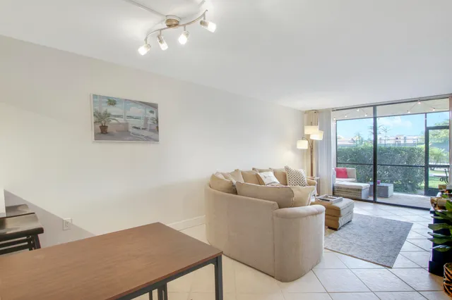a living room with furniture and a floor to ceiling window