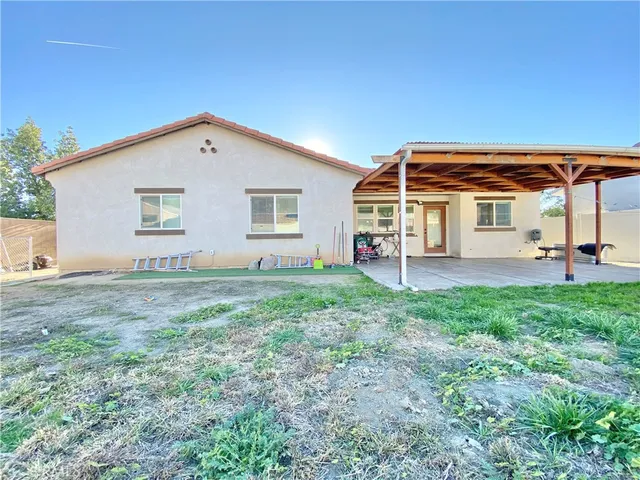 a view of a house with backyard and a tree