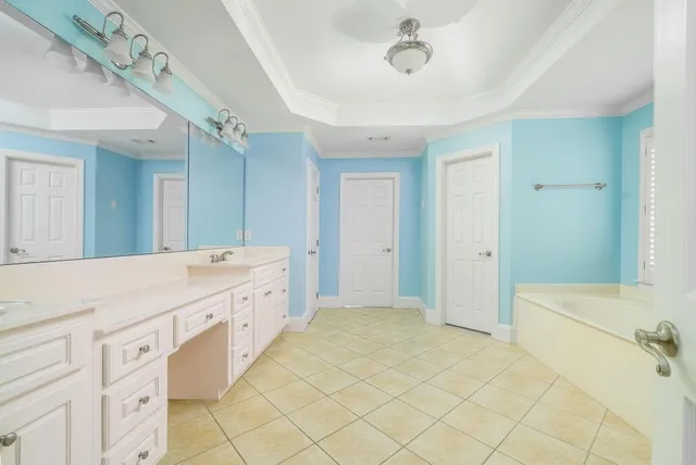 a spacious bathroom with a double vanity sink mirror and bathtub
