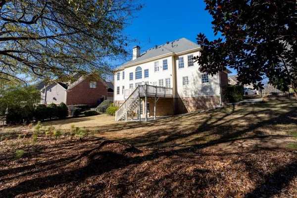 a front view of house with yard outdoor seating and covered with trees