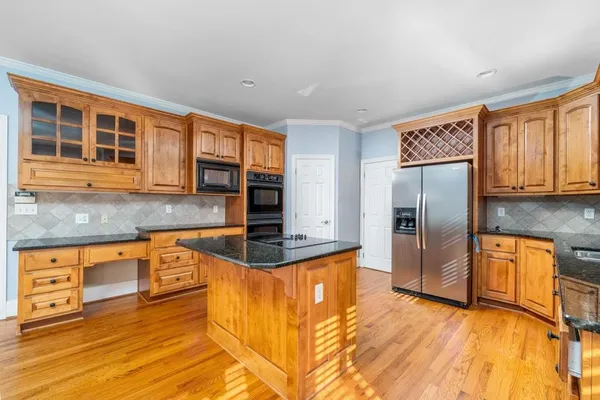 a kitchen with stainless steel appliances granite countertop a refrigerator a stove and a sink with granite countertops