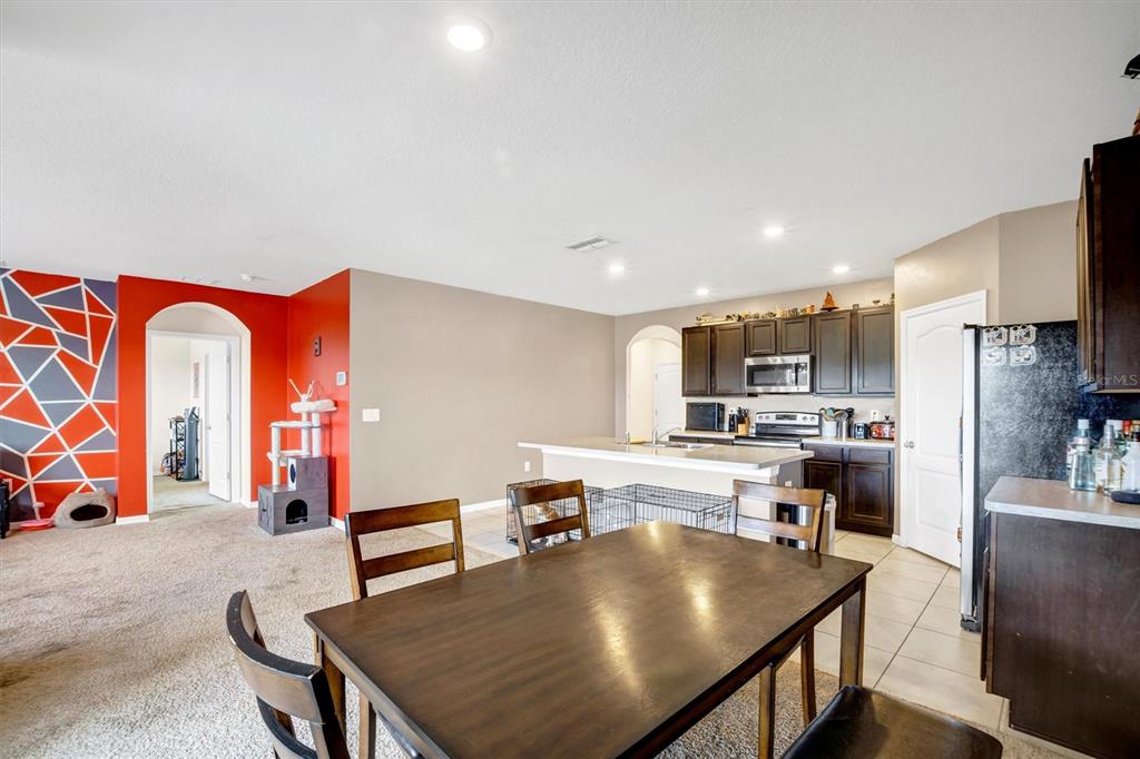 180 Grove Branch Road Winter Haven, FL 33880 - Photo 12 of 49 a living room with stainless steel appliances furniture a rug and a kitchen view