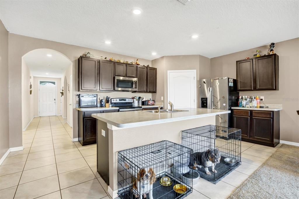 180 Grove Branch Road Winter Haven, FL 33880 - Photo 13 of 49 a kitchen with stainless steel appliances kitchen island granite countertop a sink and cabinets