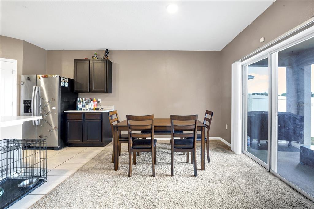 180 Grove Branch Road Winter Haven, FL 33880 - Photo 14 of 49 a kitchen with stainless steel appliances a refrigerator a stove a dining table and chairs