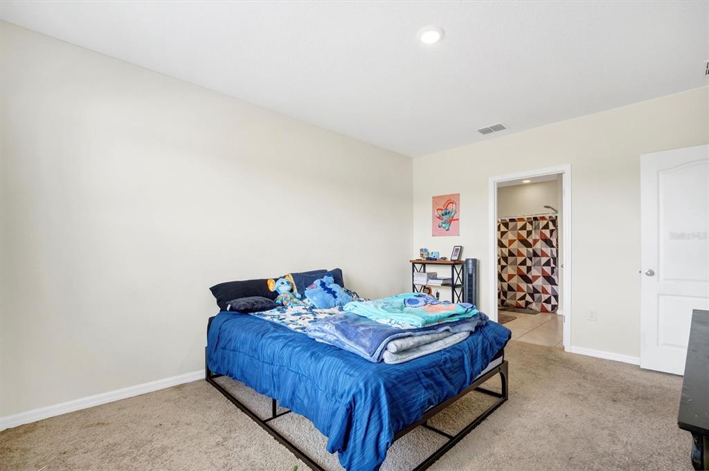 180 Grove Branch Road Winter Haven, FL 33880 - Photo 19 of 49 a bed sitting in a bedroom next to a window and a white wall