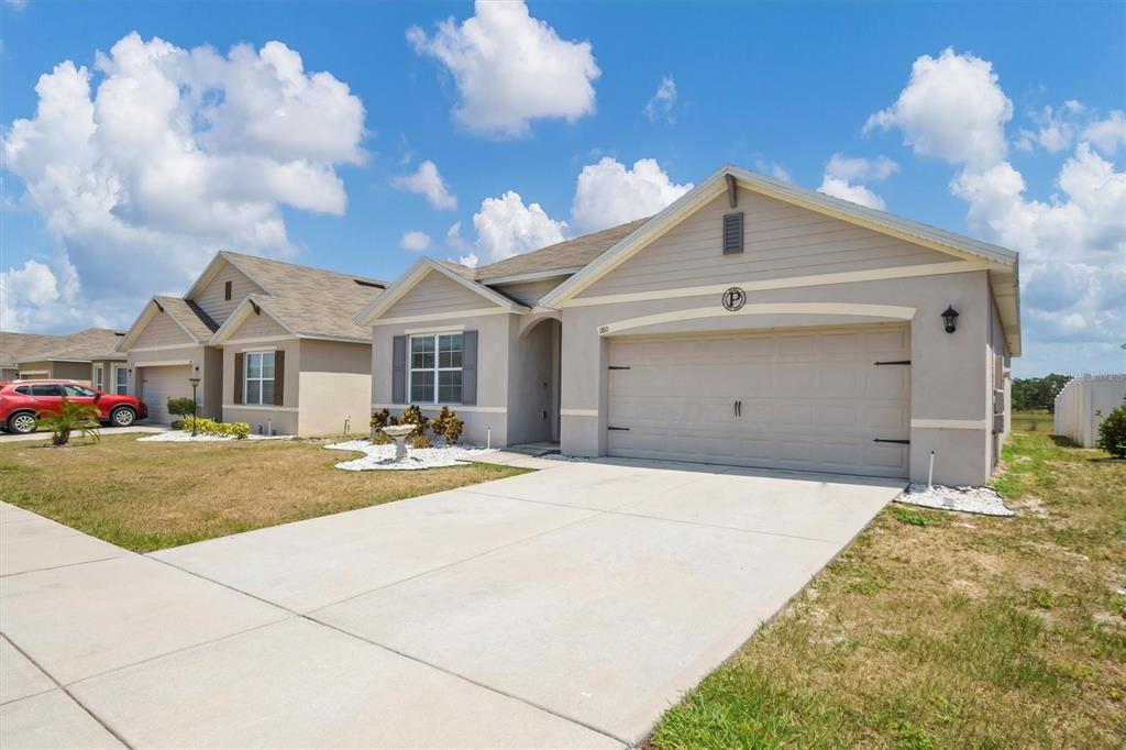 180 Grove Branch Road Winter Haven, FL 33880 - Photo 2 of 49 a front view of a house with yard and tress