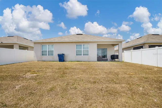 a view of a house with a backyard and a garage