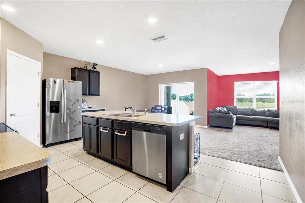 180 Grove Branch Road Winter Haven, FL 33880 - Photo 8 of 49 a kitchen with stainless steel appliances kitchen island granite countertop a refrigerator and a stove top oven
