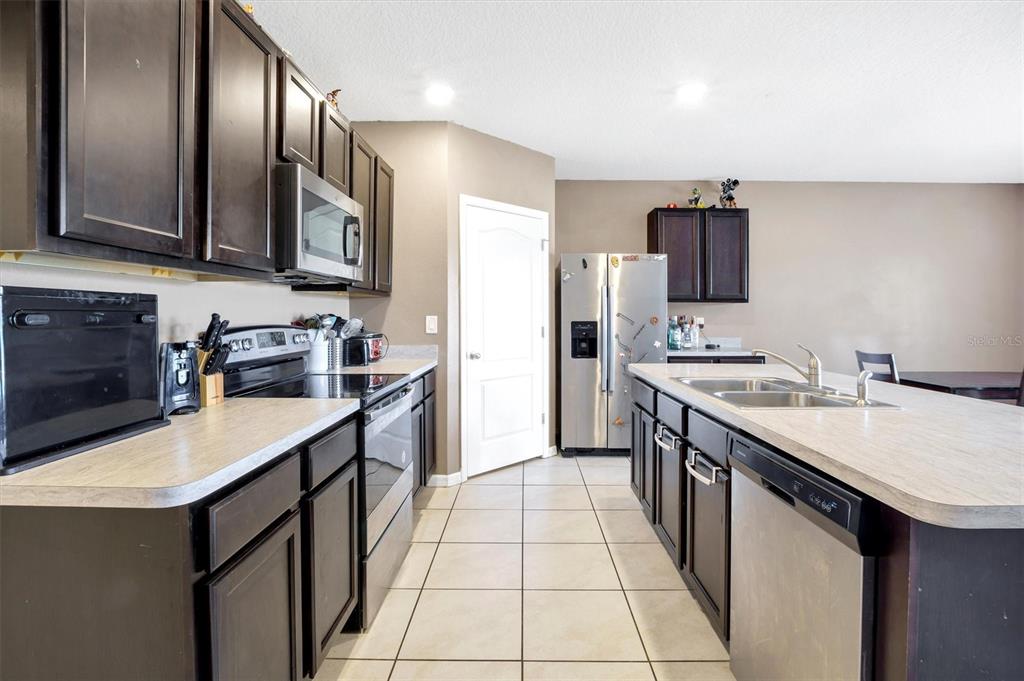 180 Grove Branch Road Winter Haven, FL 33880 - Photo 9 of 49 a kitchen with stainless steel appliances a sink stove refrigerator and cabinets