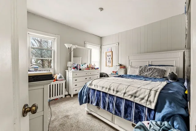 a bedroom with a bed and a large window