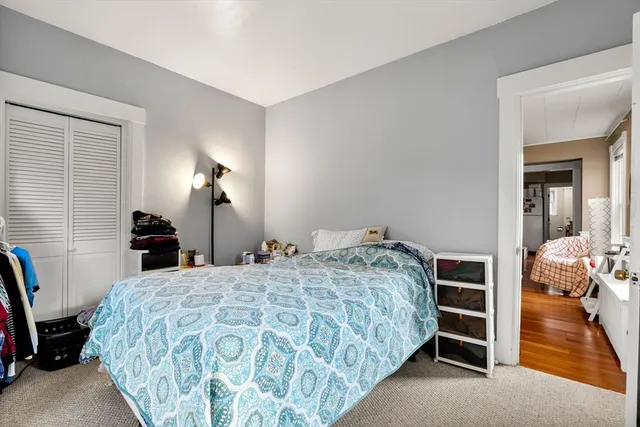 a bedroom with a bed and a lamp on the dresser