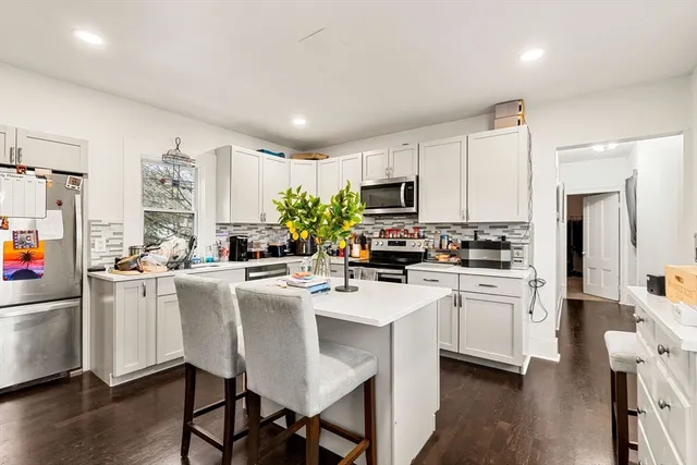 a kitchen with white cabinets and white appliances