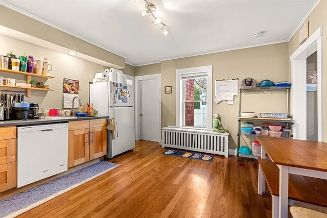 a kitchen that has a lot of white cabinets and wooden floor
