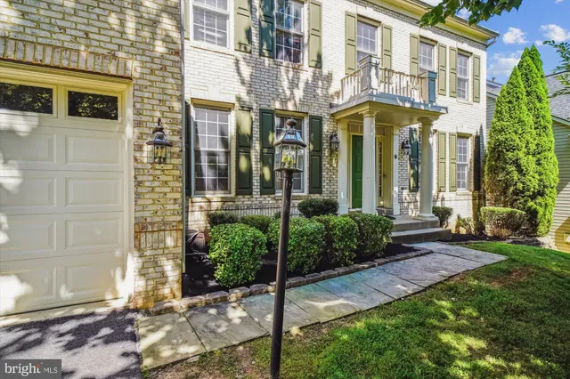 a kitchen with stainless steel appliances kitchen island granite countertop a refrigerator a sink dishwasher and white cabinets with wooden floor