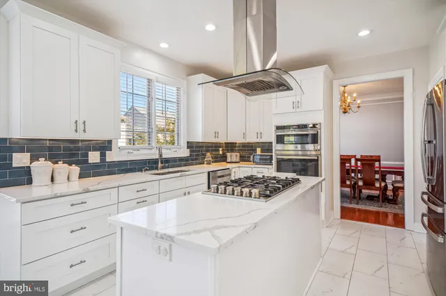 a kitchen with stainless steel appliances a stove a sink and a refrigerator