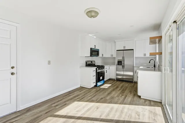 a kitchen with a refrigerator a stove top oven a counter space and cabinets