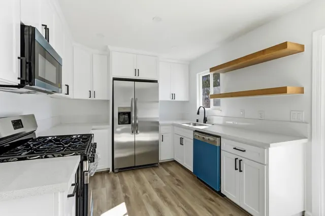 a kitchen with stainless steel appliances a sink stove and refrigerator