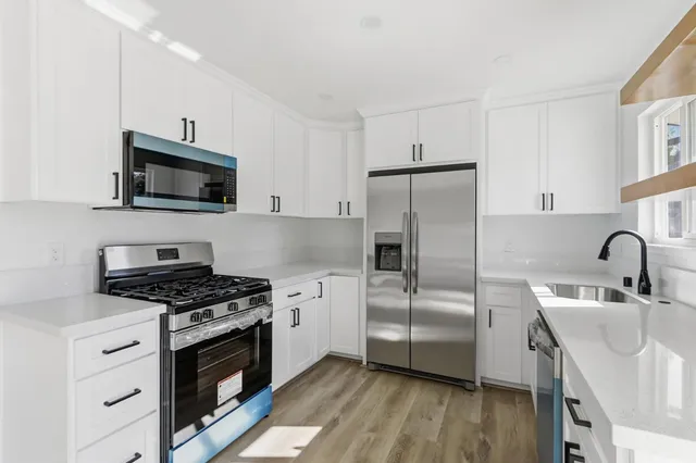 a kitchen with stainless steel appliances a stove microwave and a refrigerator