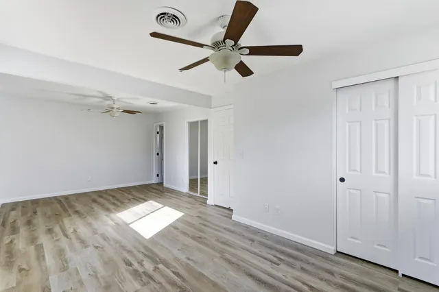 a view of empty room with wooden floor