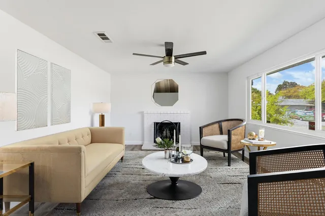 a living room with furniture a fireplace and a large window