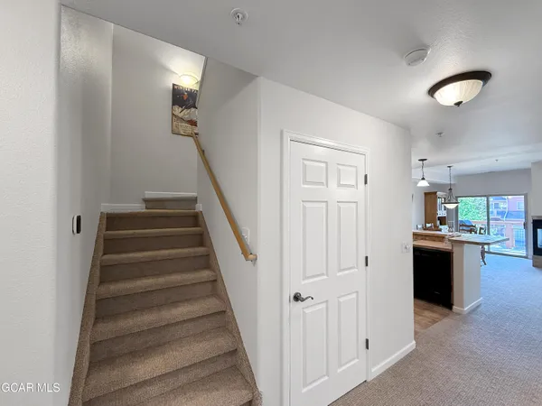 a view of a hallway with stairs and wooden floor