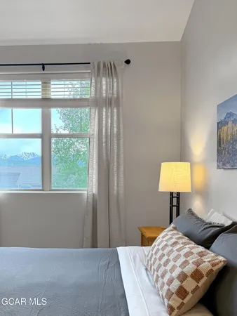 a bedroom with a bed and a lamp next to a window