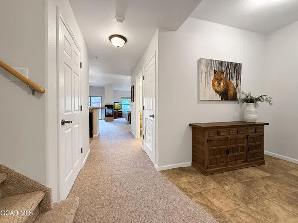 a view of a hallway to rooms and stairs