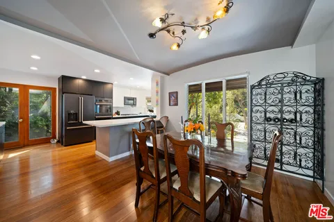 a view of a dining room with furniture a chandelier and wooden floor