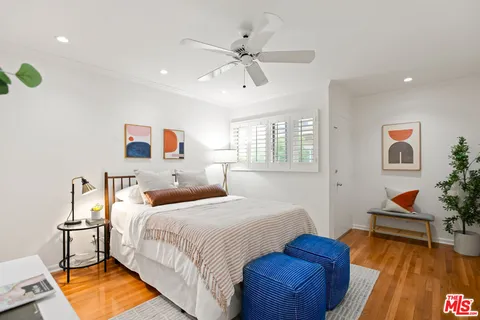 a bedroom with a large bed and wooden floor