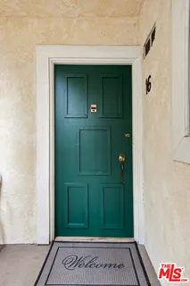 a view of a hallway with wooden floor and a bathroom