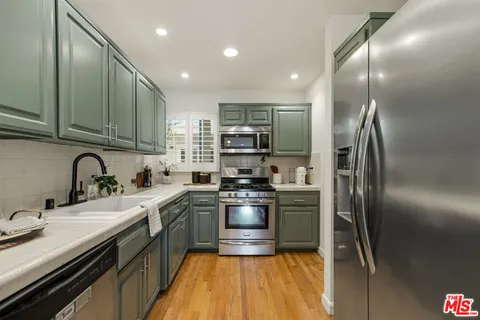 a kitchen with stainless steel appliances granite countertop a sink stove and cabinets
