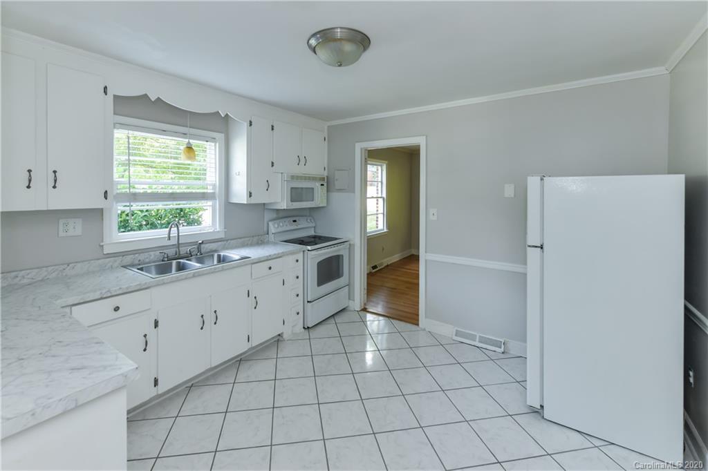 2255 Falmouth Road Charlotte, NC 28205 - Photo 13 of 28 a kitchen with a sink a stove and cabinets