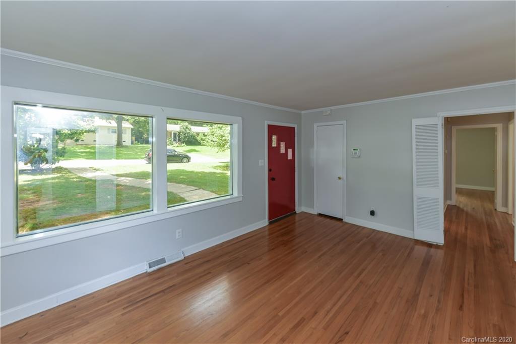 2255 Falmouth Road Charlotte, NC 28205 - Photo 7 of 28 a view of an empty room with wooden floor and a window