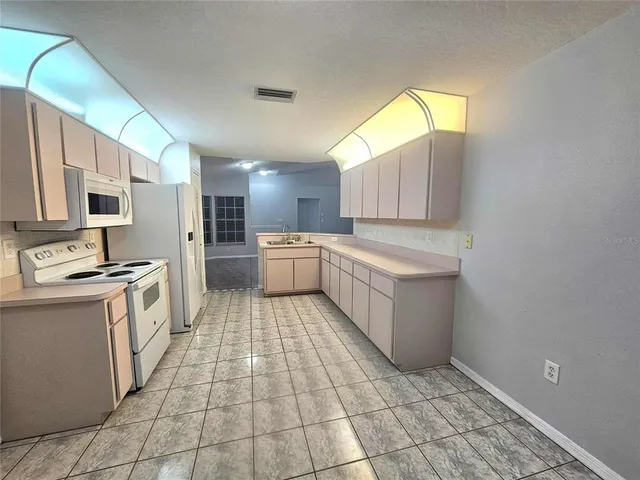 a large kitchen with a stove a sink dishwasher and a refrigerator