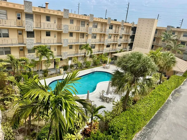 a view of a tall building with a yard and lawn chairs